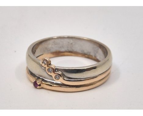 A 14ct bi-colour gold, ruby and diamond ring, with three round brilliant cut diamonds in rub-over settings and claw set singl