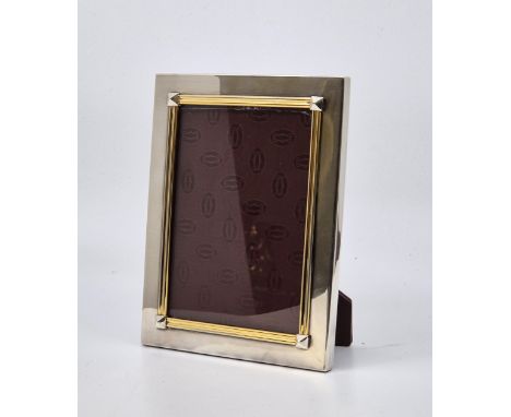 A Cartier white metal rectangular easel back photograph frame, with raised yellow metal and square bezel border, stamped "Car