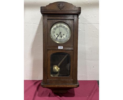 A 1930s oak cased wall clock. 32" high.