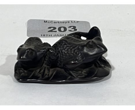 A Japanese hardwood netsuke carved as a group of three frogs. 2" wide. Meiji