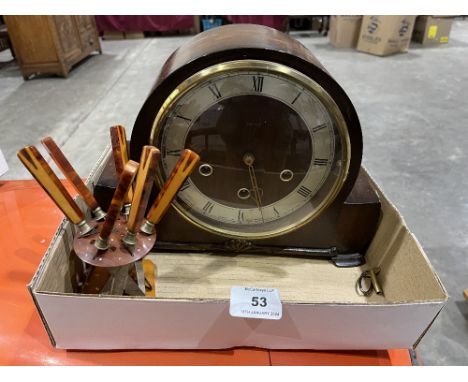 A 1940s mantle clock and a set of cake knives on a stand