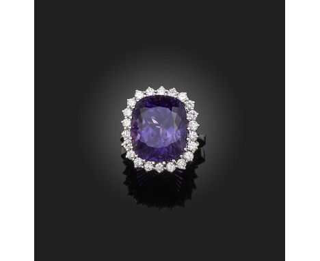 An amethyst and diamond ring, set with a cushion-shaped amethyst within a border of brilliant-cut diamonds, mounted in 18ct w