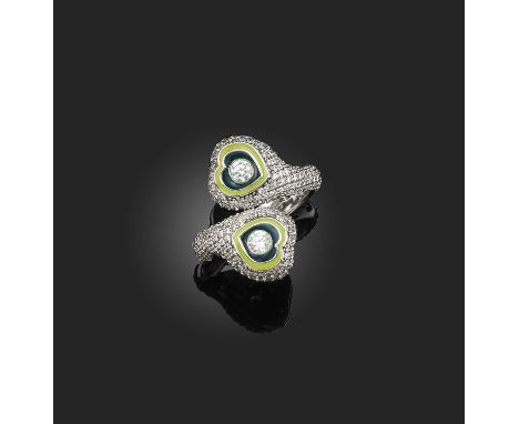 A diamond and enamel ring, the crossover design featuring two green enamel hearts each centred with a brilliant-cut diamond, 