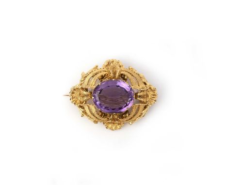 A gold and amethyst brooch, mid 19th century, set with an oval amethyst within a brooch of scrolled design composed of stampe