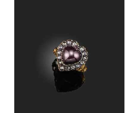 A garnet and diamond ring, of heart-shaped design, centring on a garnet cabochon surrounded by rose-cut diamonds, the shank d