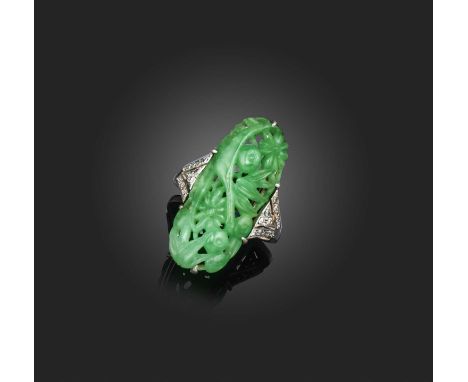 An Art Deco jadeite and diamond ring, 1920s, set with an oval jadeite plaque carved and pierced with a design of fruiting bra