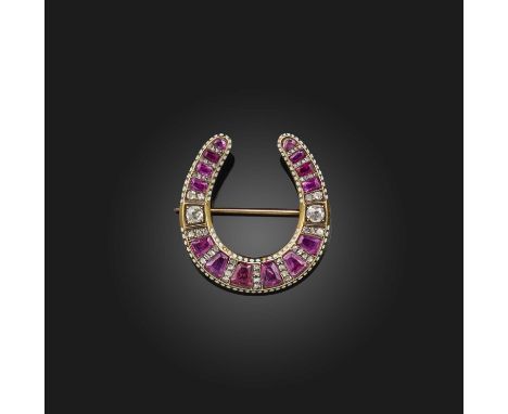 A ruby, enamel and diamond brooch, mid 19th century, designed as a horseshoe, set with cushion-shaped rubies and cushion-shap