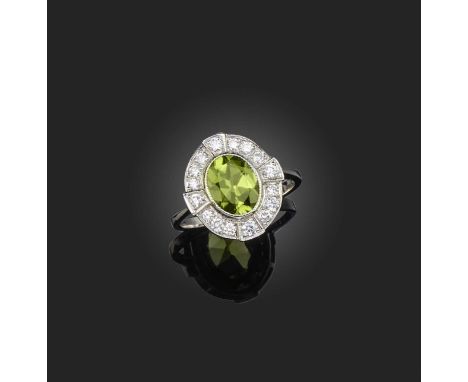 A peridot and diamond cluster ring, the cushion-shaped peridot weighing 1.70cts, in a surround of brilliant-cut diamonds, all