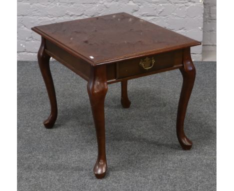 A hardwood single drawer lamp table crossbanded and raised on cabriole legs.
