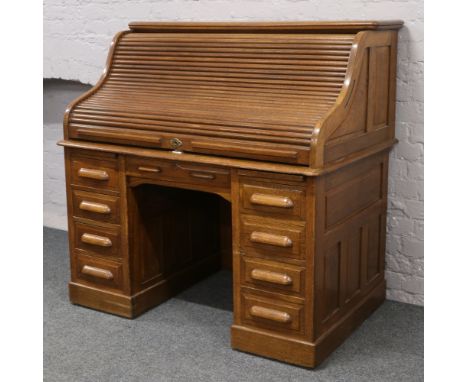 A mid 20th century oak twin pedestal tambour front roll top desk with fitted interior, Length 127cm x Height 126cm x Depth 81