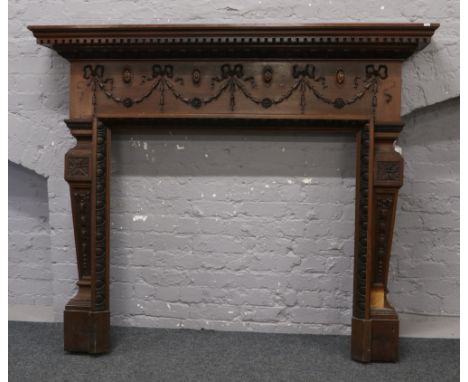 An early 20th century fire surround of large proportions decorated with swags and bows Width 178cm x Height 149cm x Depth 30c