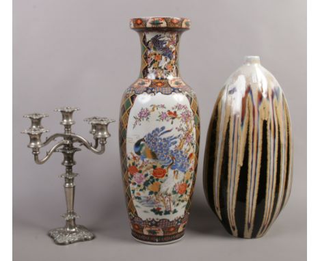 A large decorative Chinese ceramic vase, along with another art vase and a silver plate candelabra.