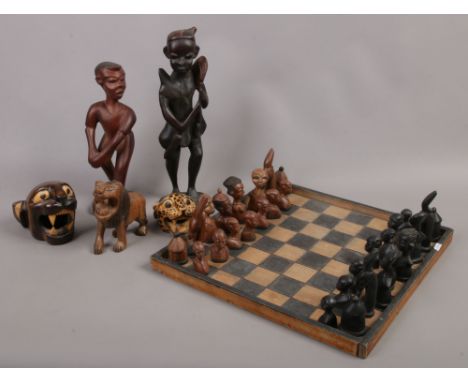 A tribal style carved hardwood chess set and board, along with similar figural carvings.Condition report intended as a guide 