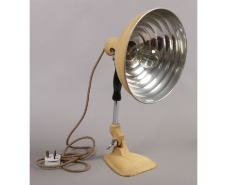 A vintage heat lamp converted to a table lamp with filament bulb.
