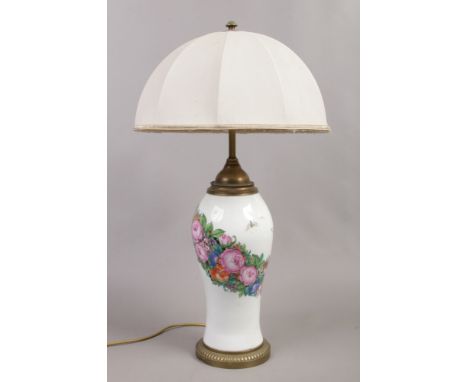 A brass and ceramic based three branch table lamp decorated with flowers and butterflies.
