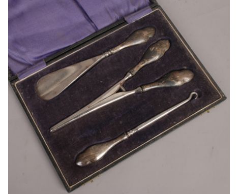 A cased silver handled glove stretcher button hook and shoe horn set, assayed Birmingham 1922.