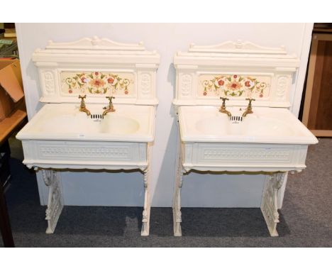 A pair of Victorian ladies and gents wash basins on painted cast iron stands with tiles splash-backs and brass taps, basins m