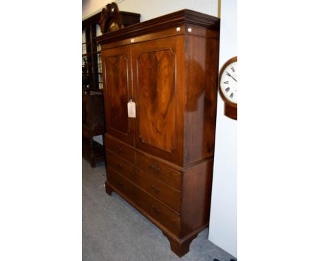 An early 19th century mahogany dwarf linen press, panelled top section raised over a chest base on bracket supports, 125cm by