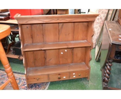 A pine wall shelf, stepped cornice, shaped sides, two shelves and three small drawers