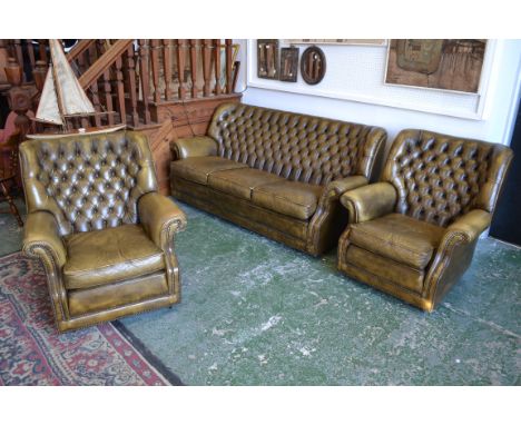 A three piece olive green leather suite, comprising three seat button back sofa and two armchairs