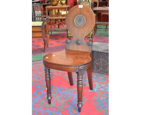 A Victorian mahogany hall chair, circular back, the central cartouche naively painted with an elephant crest, the motto Tenax