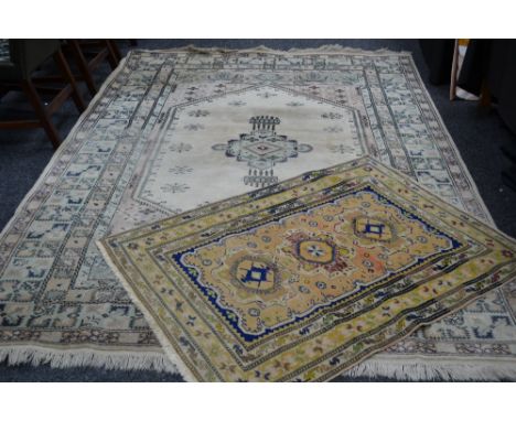 A machine woven middle eastern carpet in shades of pale green and red; another middle eastern carpet (2)