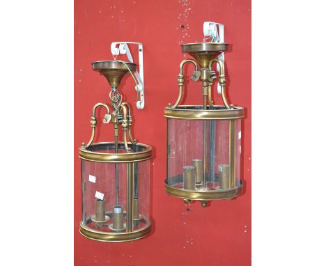 A pair of modern three light pendant lights