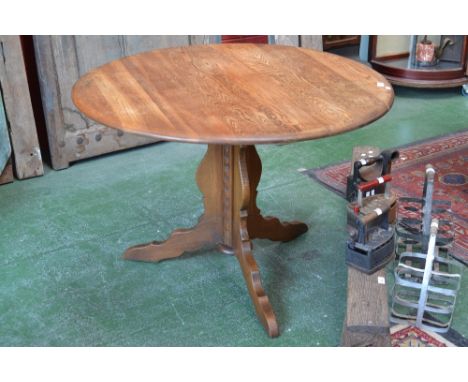 An Ercol style oak circular pedestal centre/dining table