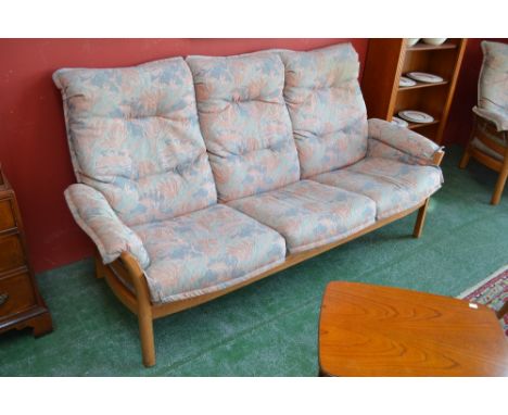 A elm Ercol three seat settee and conforming armchair 