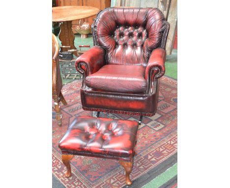 A red leather button back rocking armchair, foot stool en suite (2)
