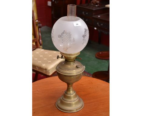 A brass paraffin lamp with opaque glass shade