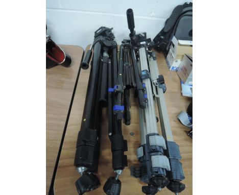 Three camera tripods including Velbon, Slik, and Atlantic