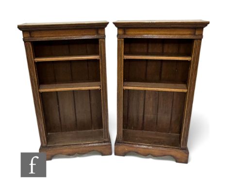 A pair of Edwardian style oak floorstanding bookcases, the adjustable shelf interior flanked by a pair of fluted pilasters on