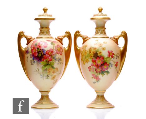 A pair of early 20th Century Royal Worcester pedestal urns and covers, shape 2158, each of slender ovoid form with large scro