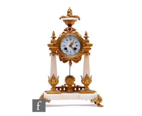 A late 19th Century French white marble and gilt mounted mantle clock, circular dial below a surmounted urn, on two obelisk p