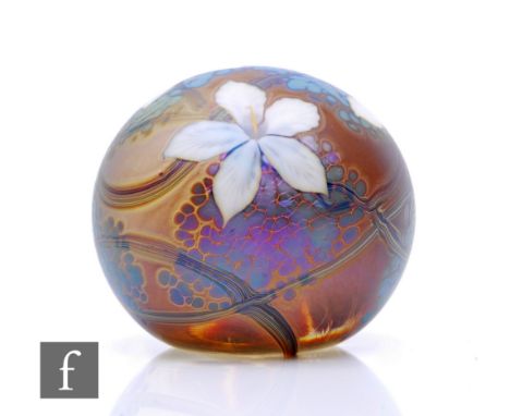 A contemporary Richard P. Golding glass paperweight, of domed form decorated to the surface with stylised flowers in purple, 