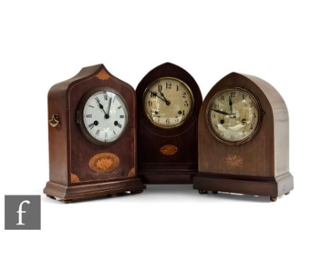 An Edwardian inlaid mahogany mantle clock, eight day striking movement, and two similar lancet shaped clocks, all with keys. 