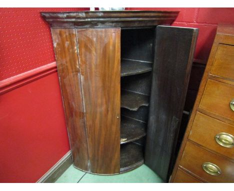 A George III flame mahogany bow fronted corner cabinet, shaped central shelf, 119cm tall