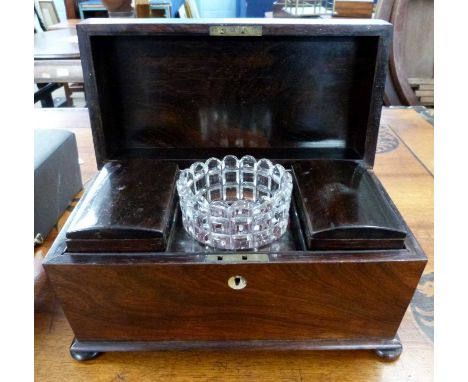 A rosewood sarcophagus formed tea caddy with hinged lid opening to an interior with central glass bowl and two further hinged