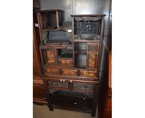 A late 19th or early 20th Century Chinese hardwood side cabinet with a abstract design with pierced fretwork decoration, four