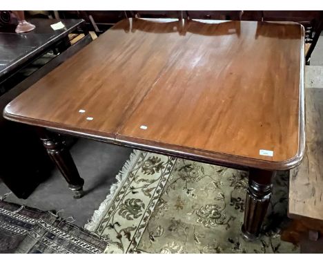 A large Victorian mahogany extending dining table on turned fluted legs with pull out action and two extra leaves, 126cm long