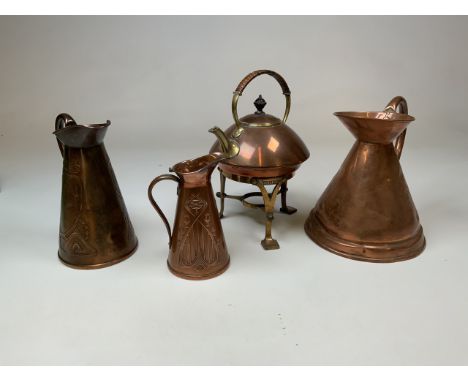 Three copper jugs , two with art nouveau decoration together with a copper and brass spirit kettle on stand in the secessioni