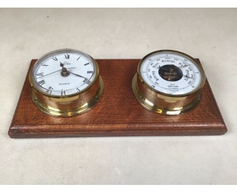 A brass barometer and clock on wooden wall mount.
