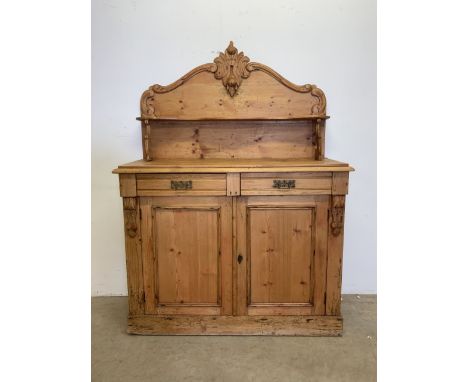 A continental stripped pine chiffonier with two large cupboard doors to shelf, double drawers and mantle shelf. W:116cm x D:4