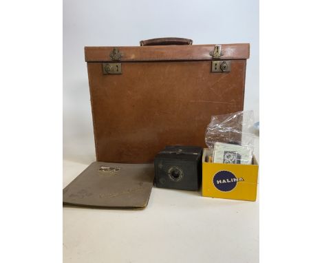 A square leather case marked Richards Maker Bath also with a brownie camera old film and an empty album.W:45cm x D:12cm x H:3