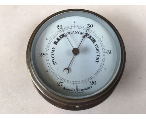 A brass aneroid barometer.