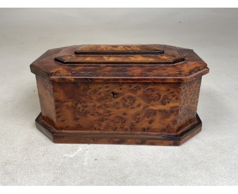 A birds eye maple tea caddy of octagonal form with offset plinth and three tier lid. W:22cm x D:15cm x H:10cm