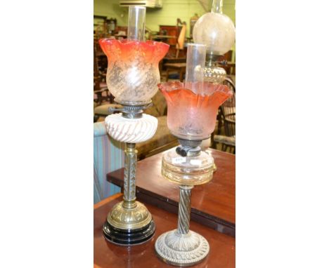 A Victorian oil lamp with brass base, opaque reservoir and a flared etched two tone shade together with a similar oil lamp wi