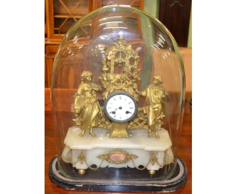 A gilt metal striking mantel clock, beneath a glass dome 