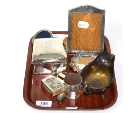 Two silver mounted photograph frames, silver mounted cigarette box, silver pin tray, silver sauce boat, silver scent bottle, 
